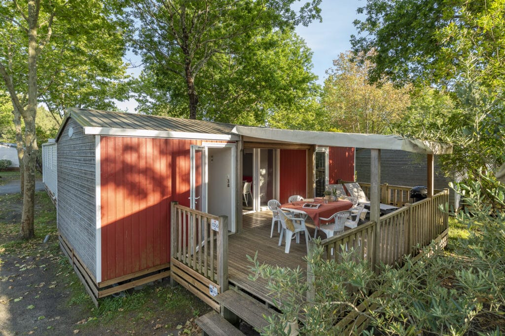 Mobil-home rouge avec terrasse ensoleillée