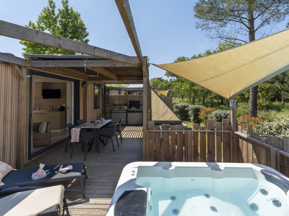 Terrasse en bois avec jacuzzi et salon extérieur.