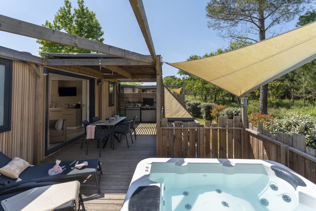 Terrasse en bois avec jacuzzi et salon extérieur.