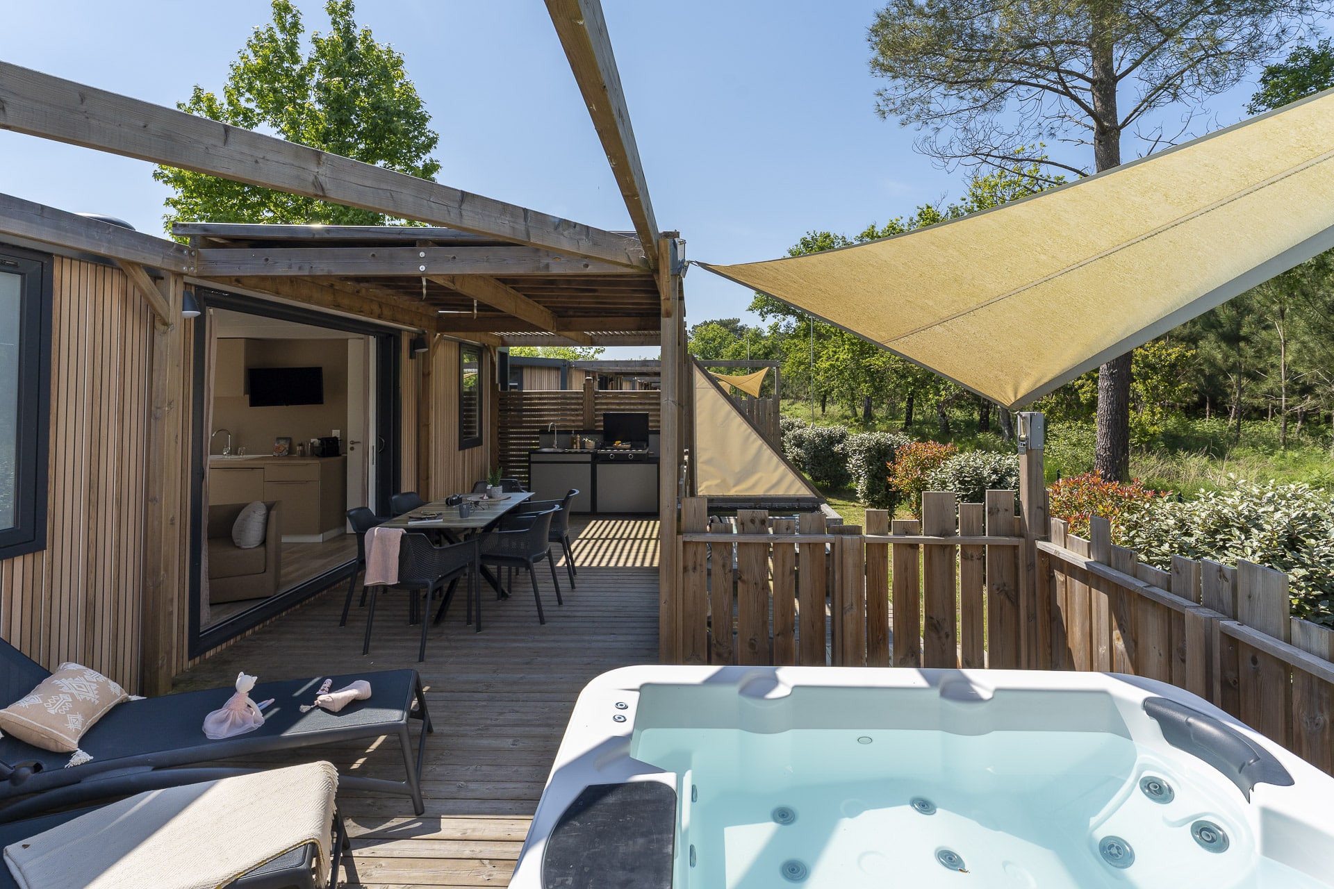 Terrasse en bois avec jacuzzi et salon extérieur.
